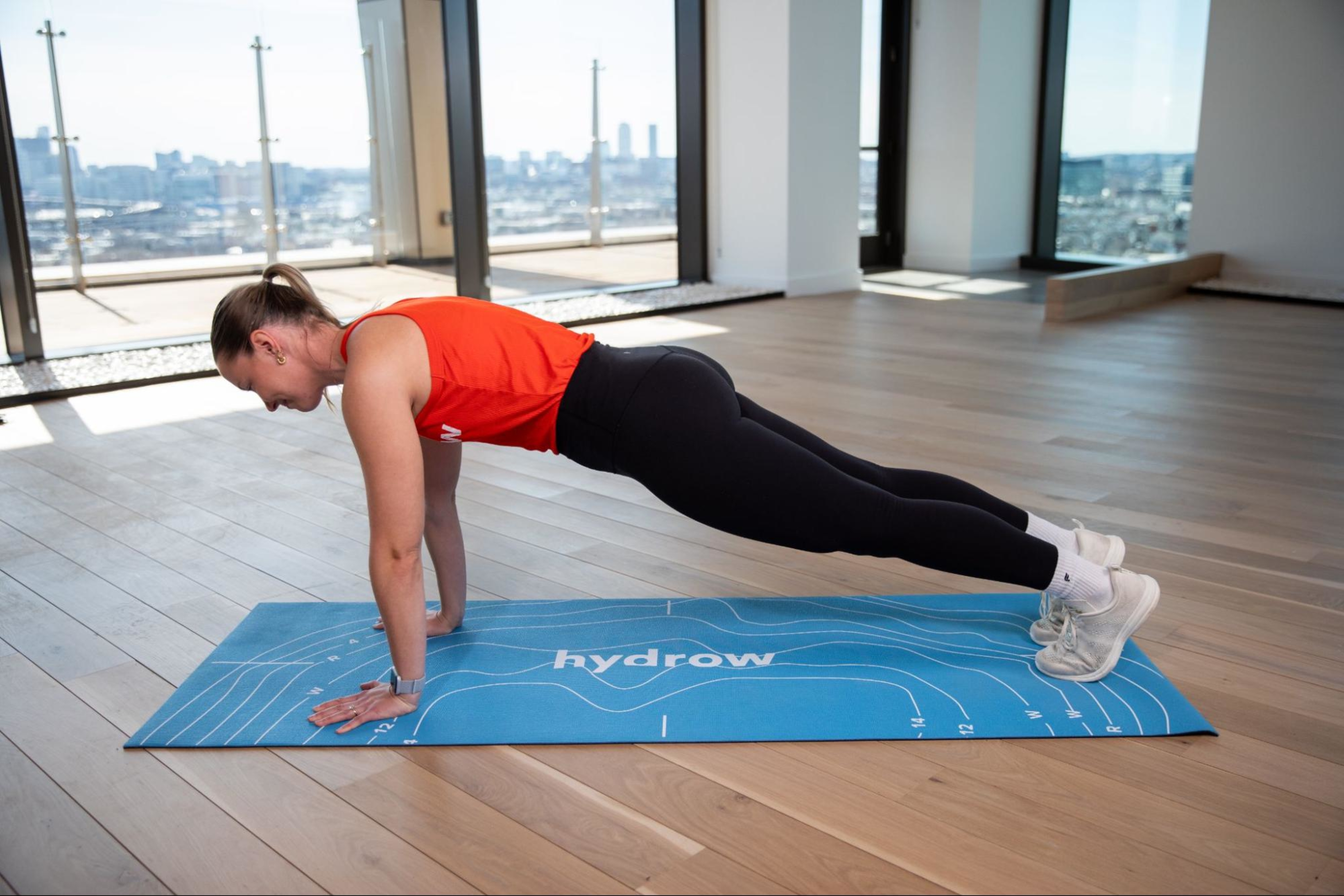 Hydrow Athlete Mac demonstrates how to do a plank, a popular strength exercise for marathon runners.