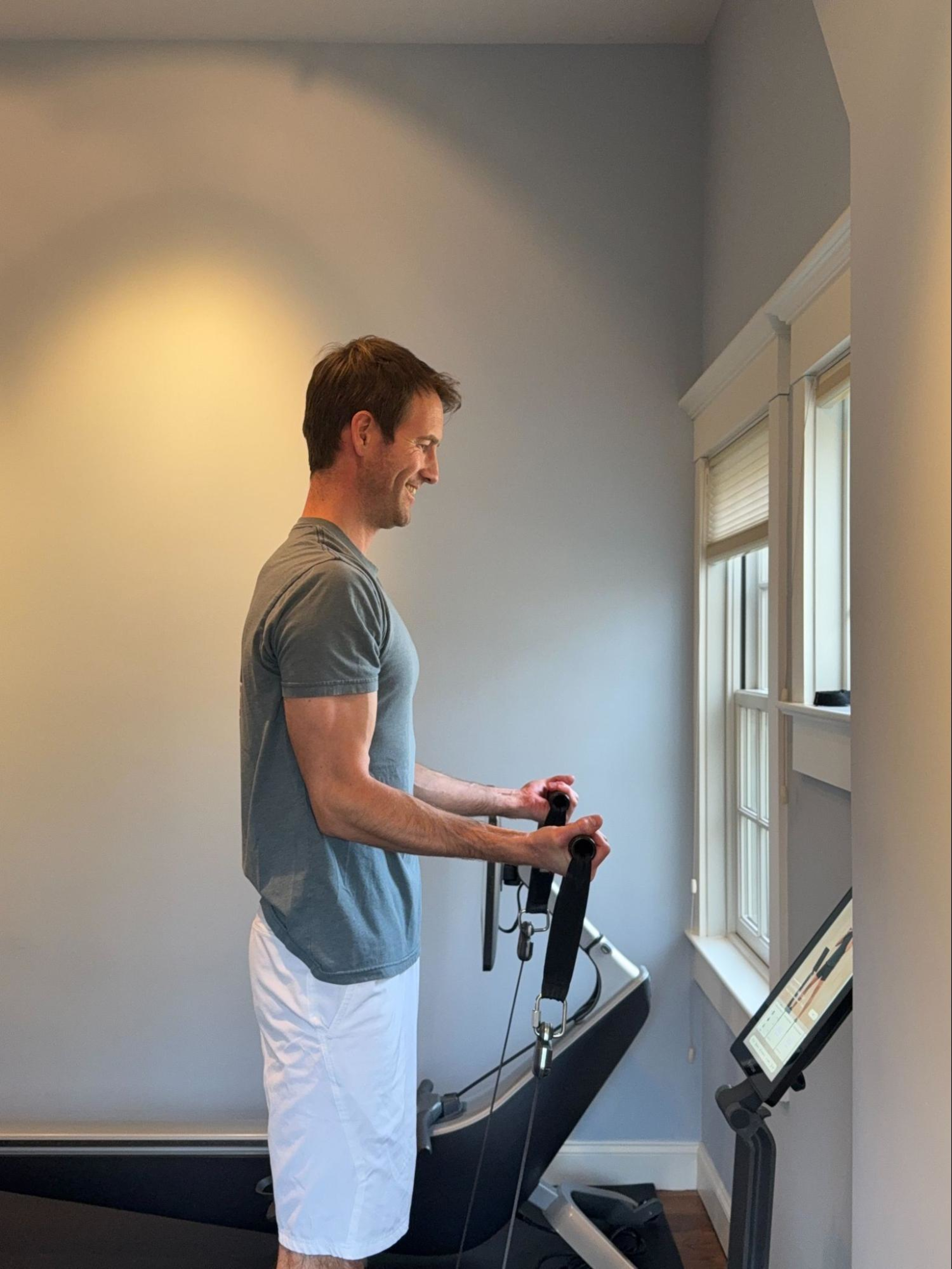 Hydrow Member Pete Abernethy uses his LYQUID strength training machine at home.