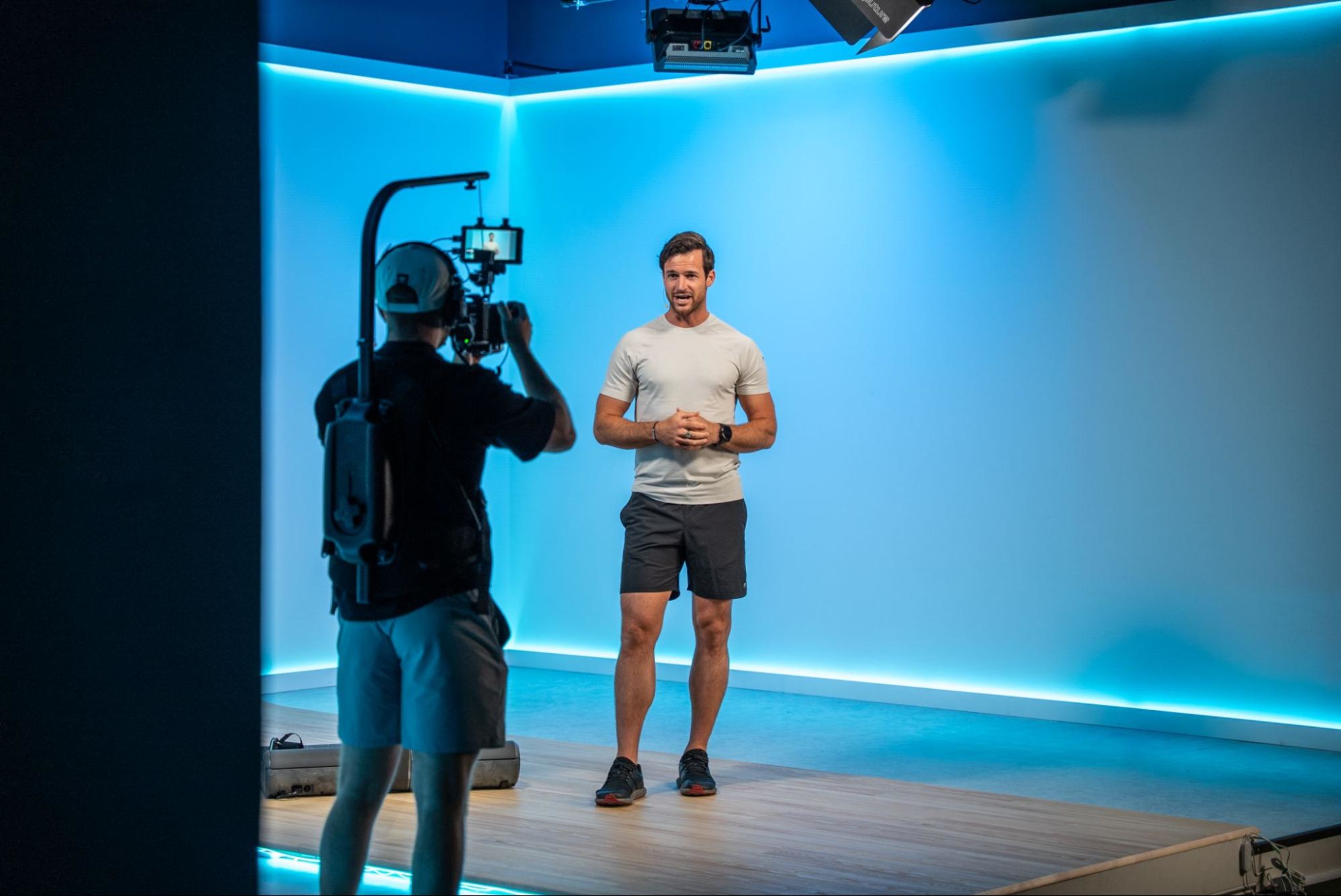 Hydrow Athlete Lance Parker films a LYQUID workout in a studio.