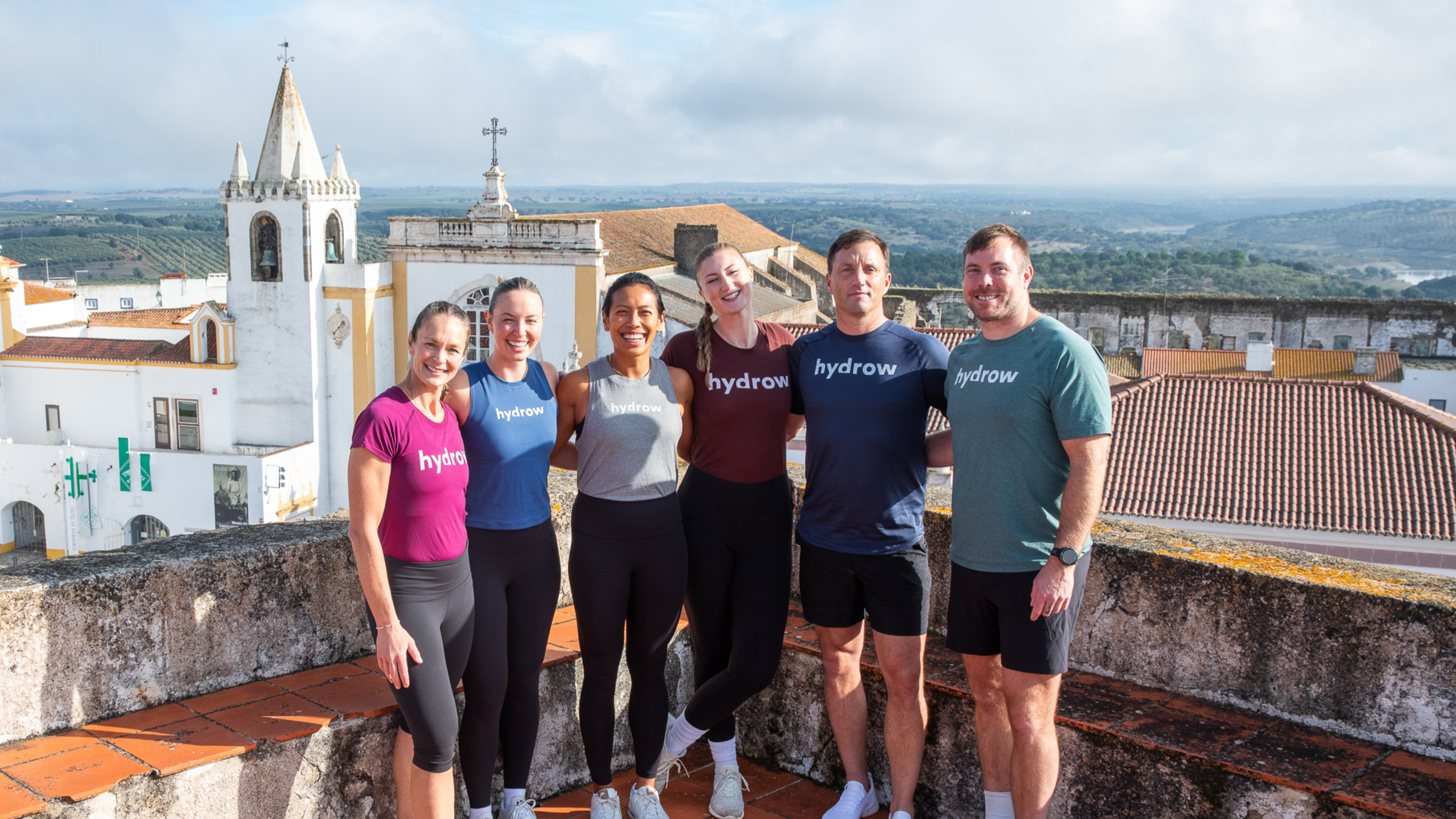 Hydrow Athletes Buffy, Mac, Aisyah, Dani, Mike, and James pose in Portugal.
