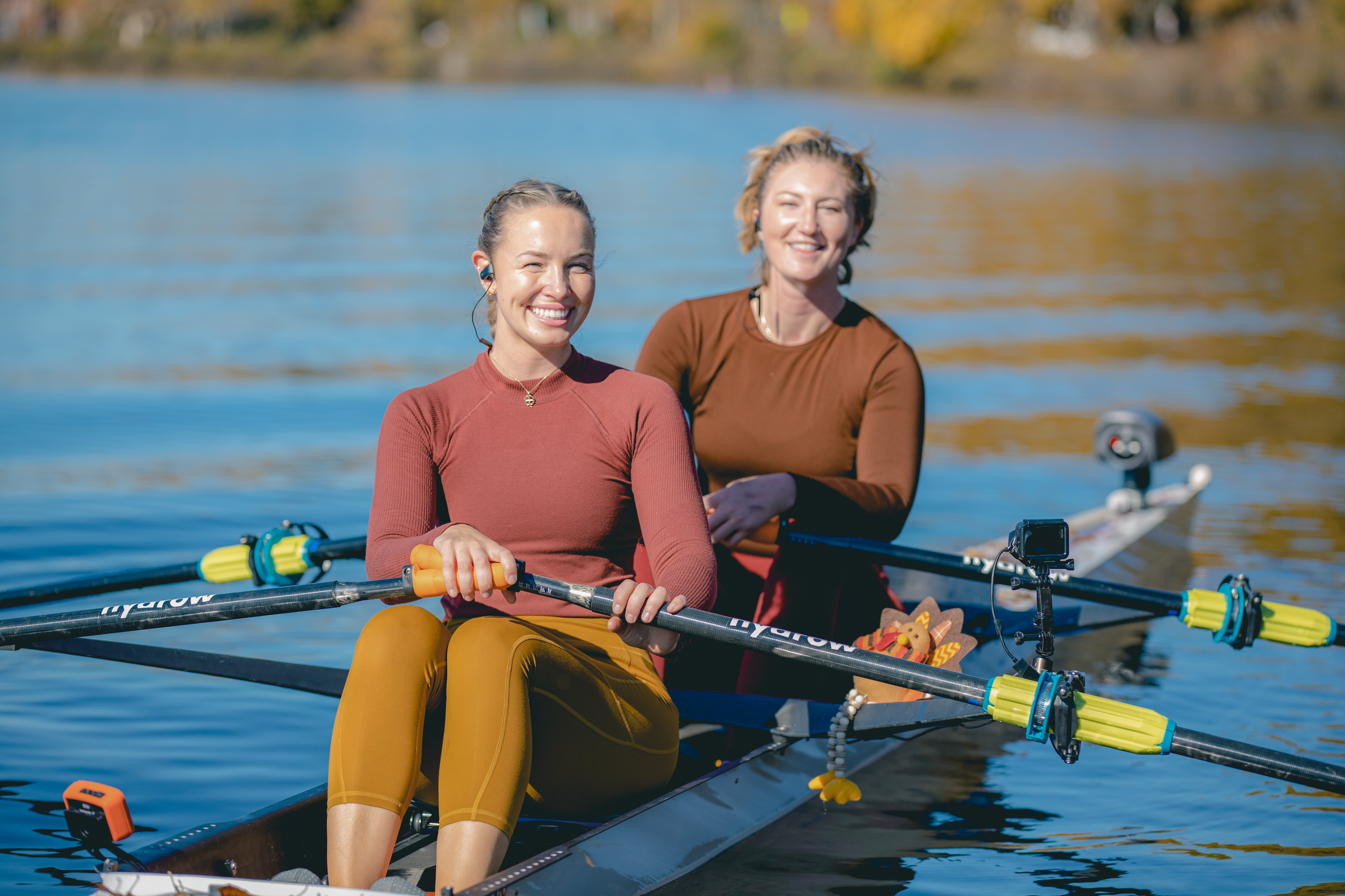 Two people rowing on a river and smiling