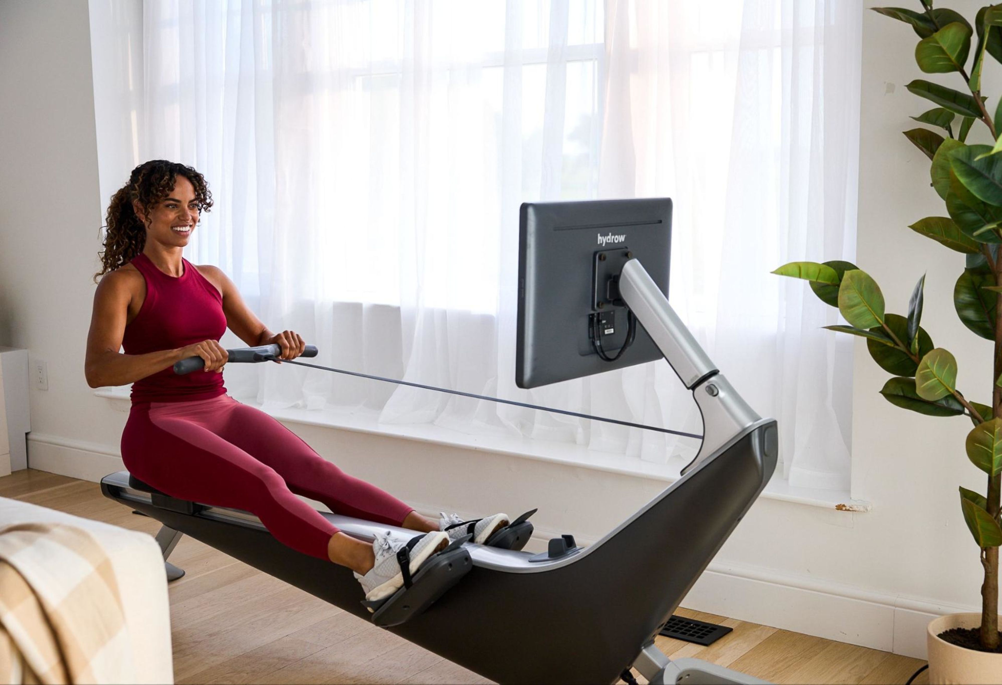 Woman does a rowing machine workout after learning whether a rowing machine workout is good for shin splints.