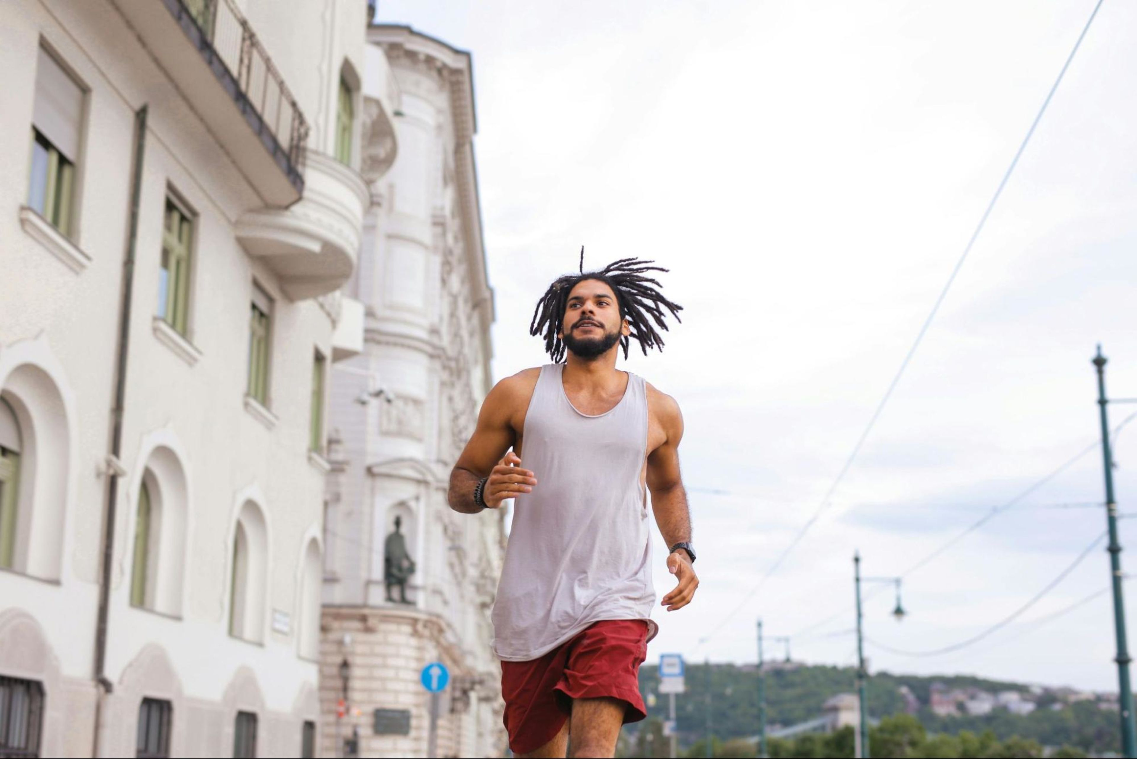 Man runs outdoors, a good example of a fitness goal to aim for.