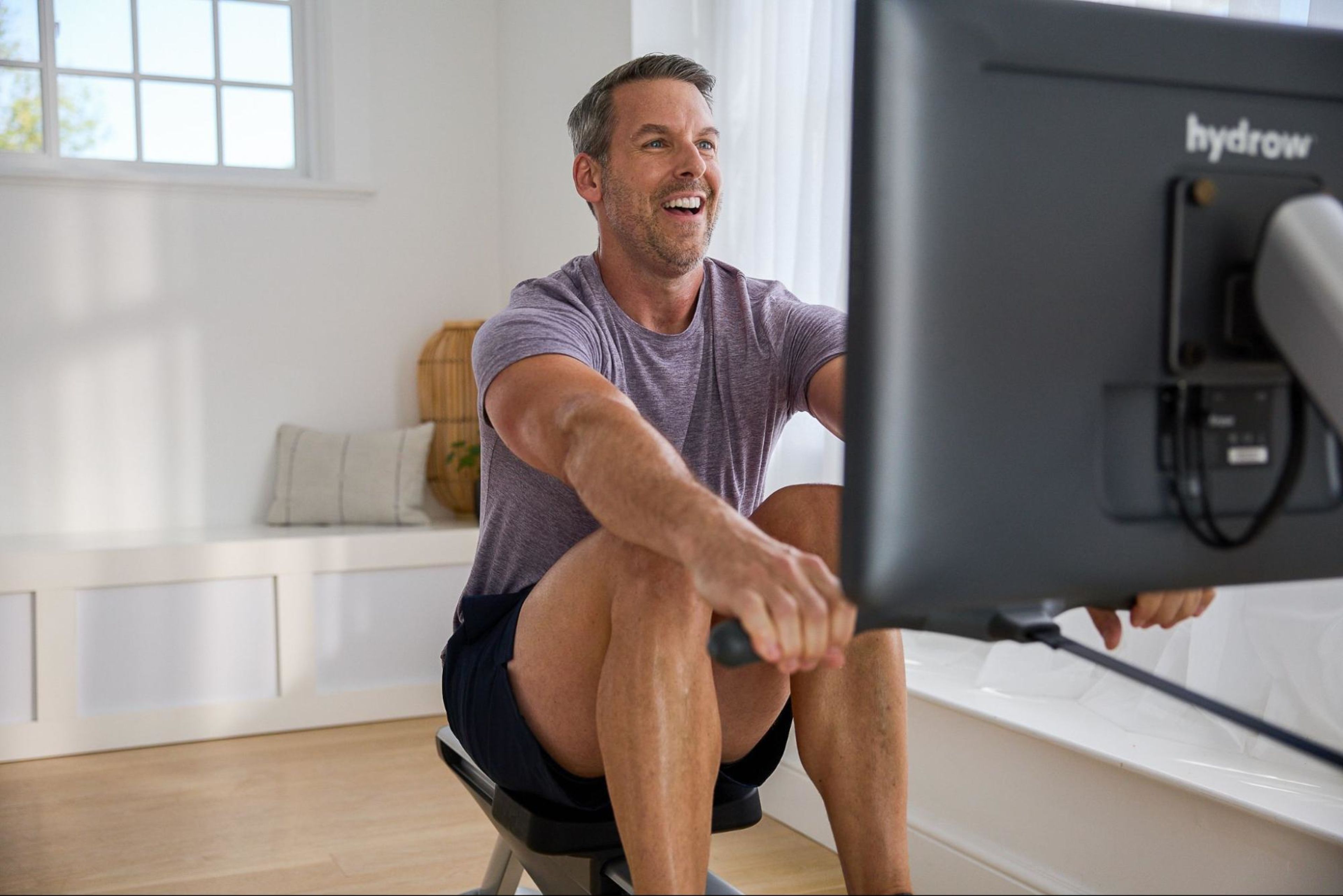 Man works out on a rowing machine after learning whether rowing machines are good for bad hips.