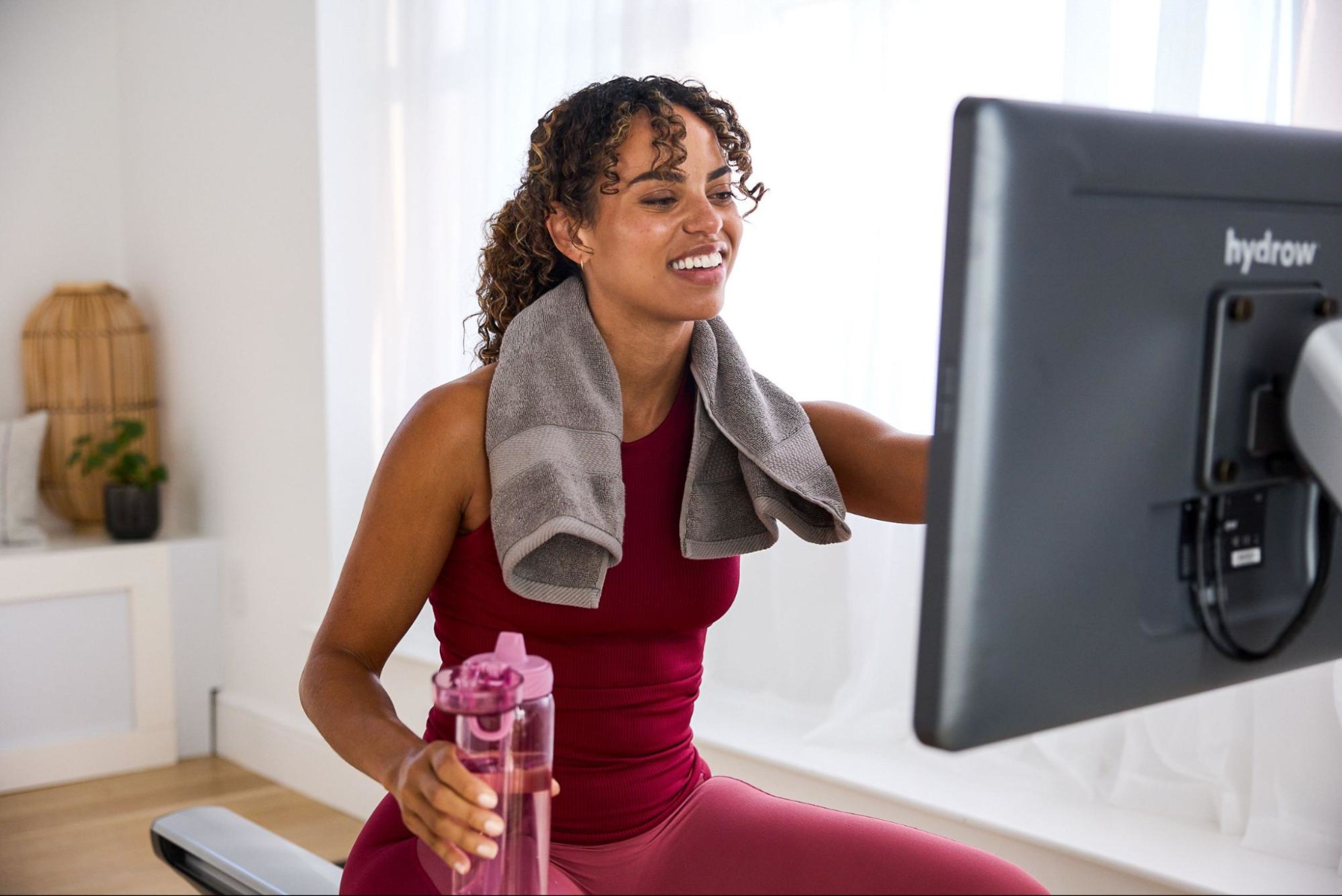 Woman works out on a rowing machine, one of the best types of cardio exercise.