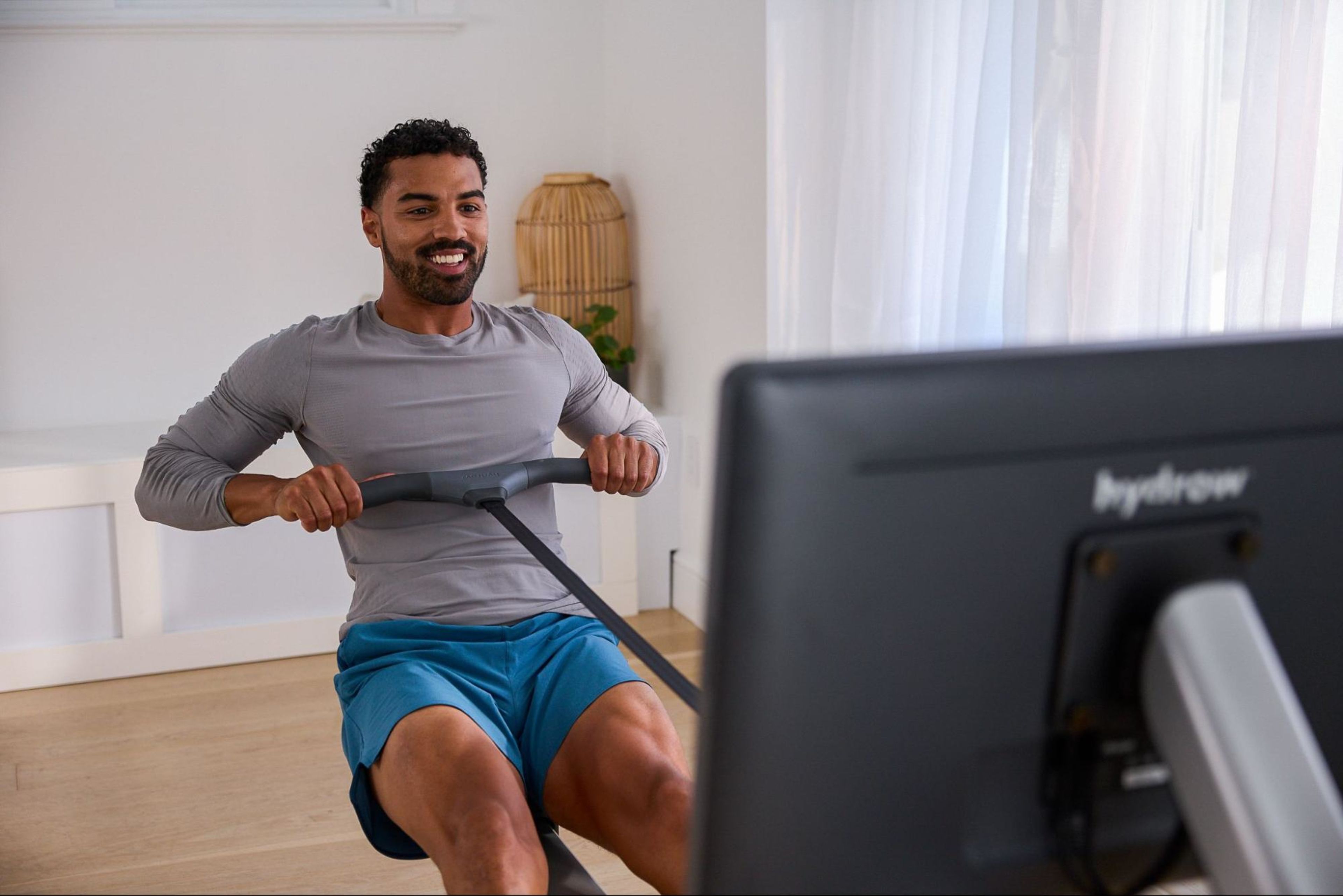 Man does a rowing machine workout on his Hydrow rower.