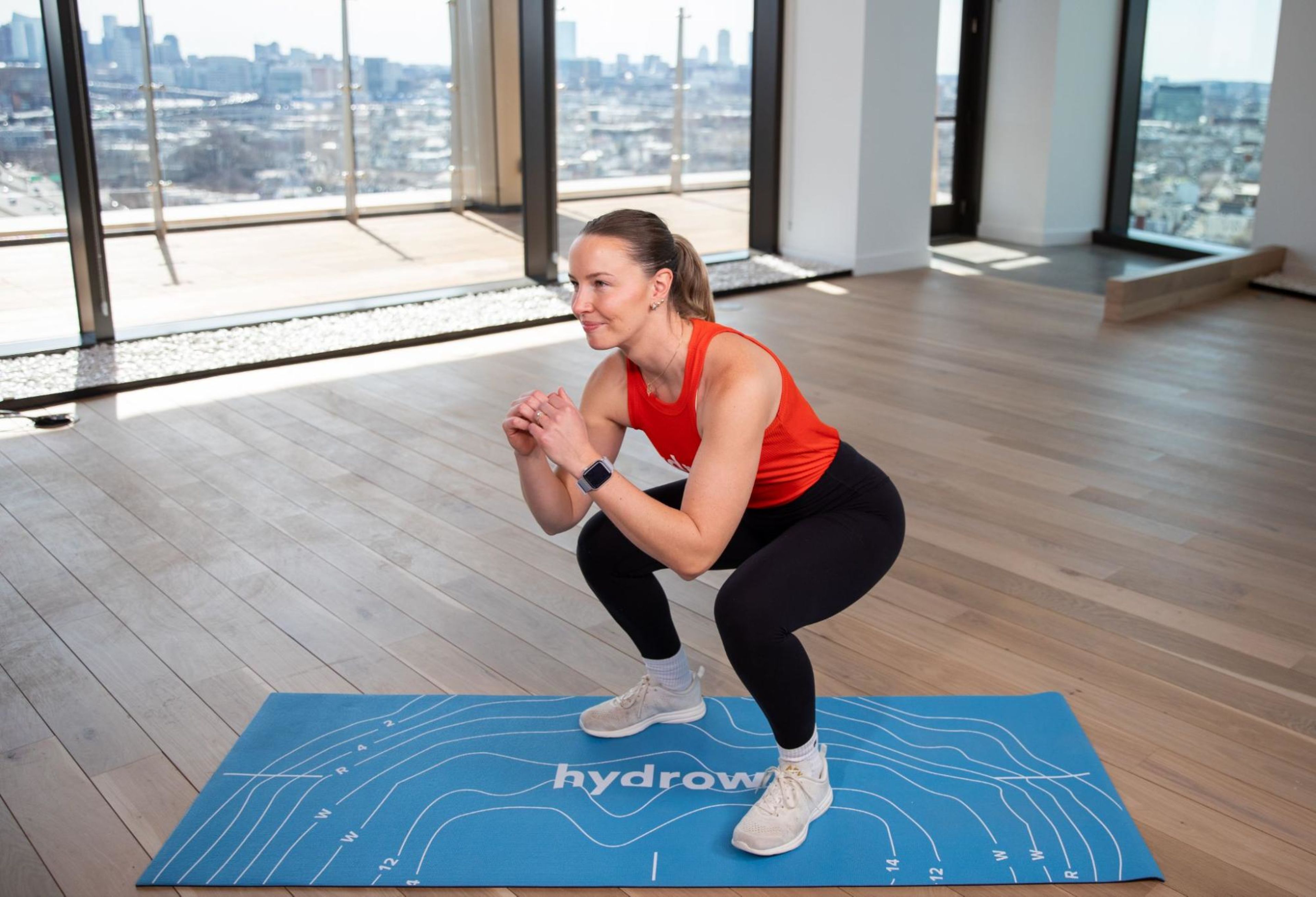 Hydrow Athlete Mac does squats as an example of full-body vs. split training.