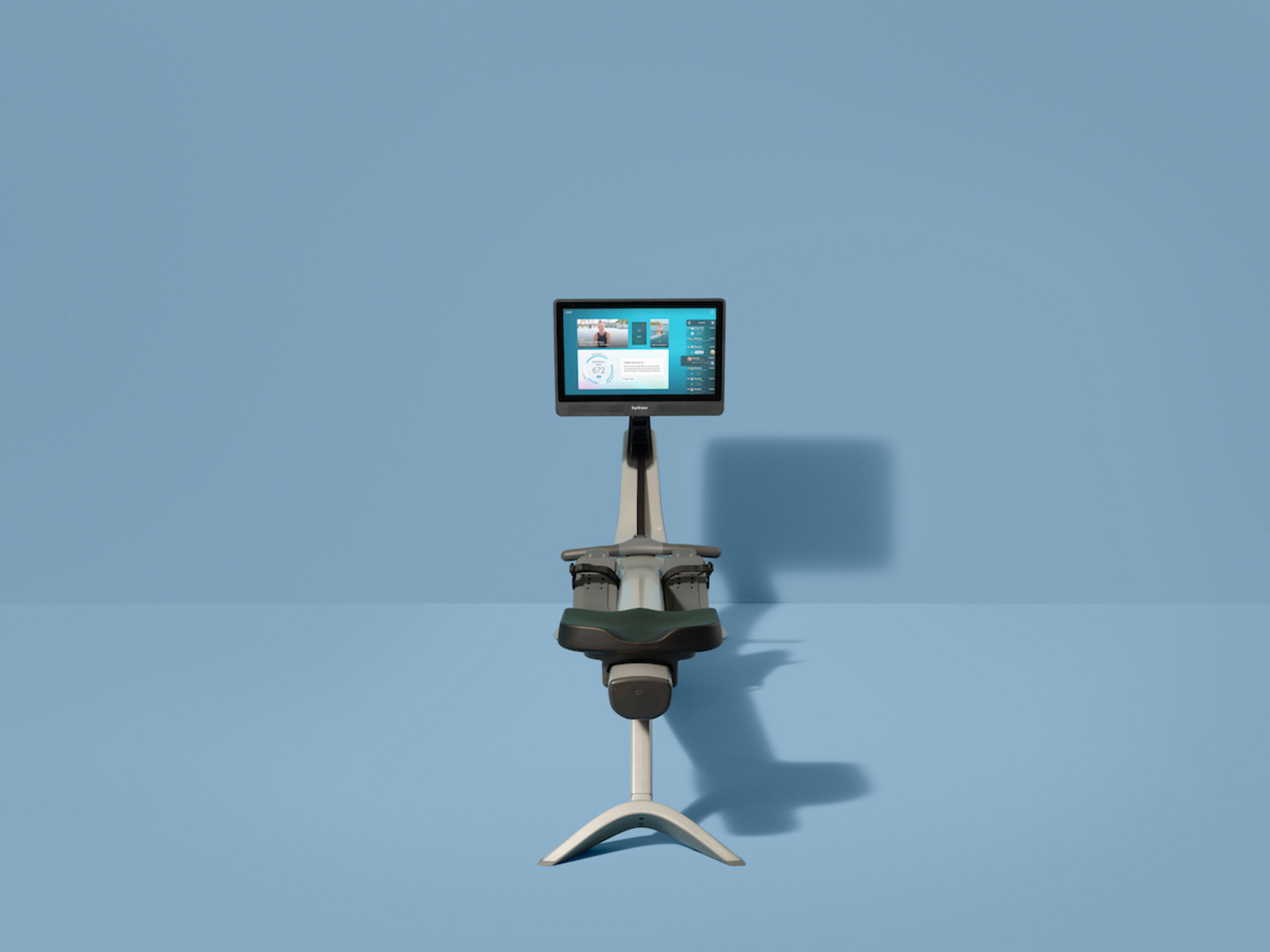 A Hydrow Arc rowing machine against a blue background.