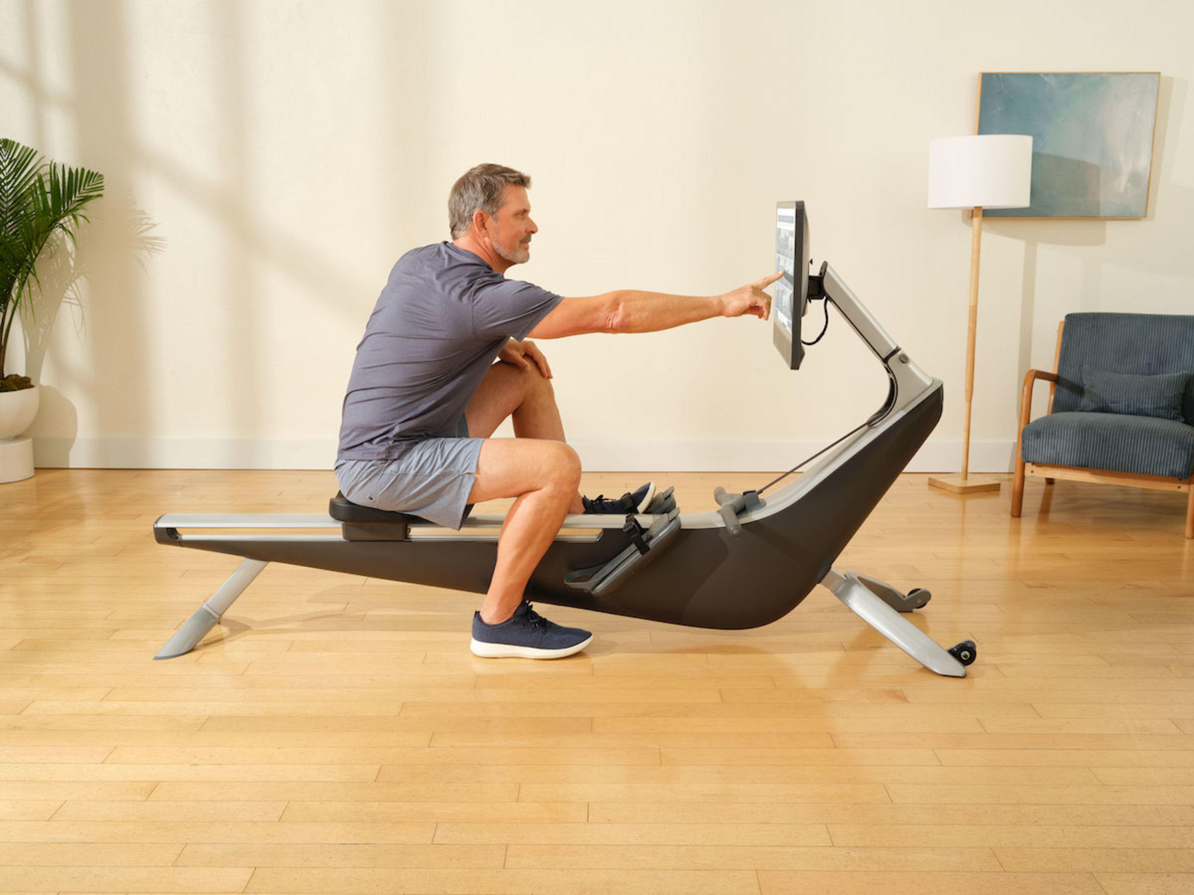 Man prepares to row on the Hydrow Arc rowing machine.