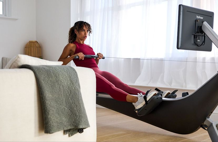 Woman demonstrates how to use a rowing machine.