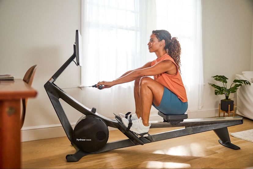 Woman works out on a rowing machine after learning about the major rowing machine benefits.