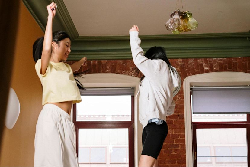 Two women make exercise fun by dancing in their living room.