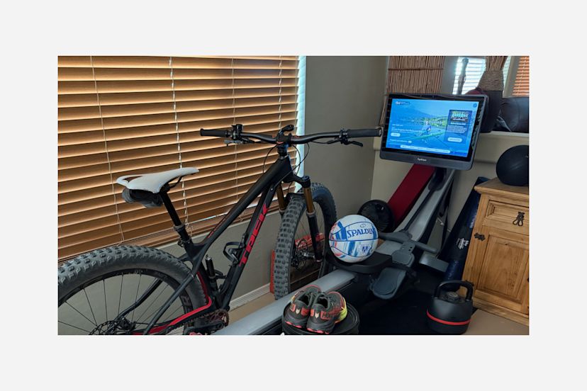 A Hydrow Member's at-home rowing machine setup, including a Hydrow rower, bike, basketball, and sneakers.