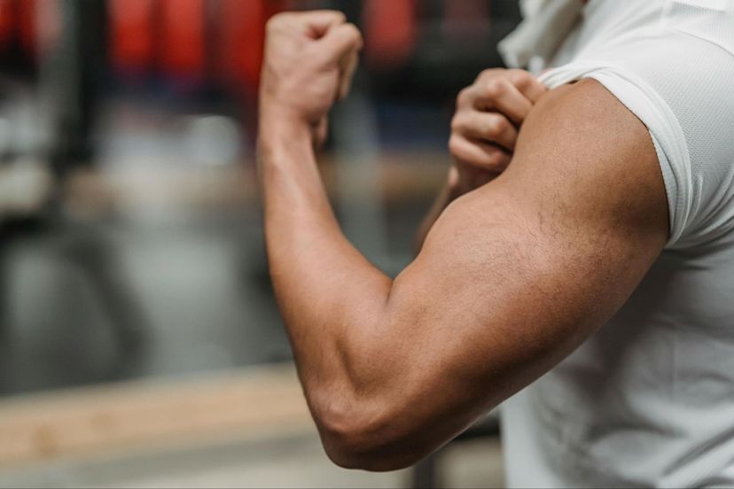 Man flexes his bicep after learning how much protein you need to build muscle.