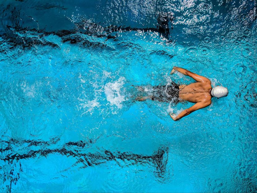 Man does a swimming workout after doing the best strength training exercises for swimmers.