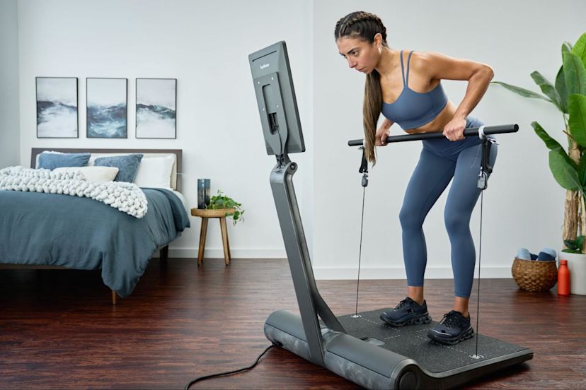 Woman does a strength workout on a LYQUID strength machine.