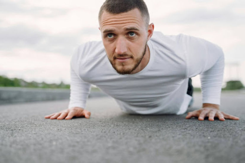 Man does a plank as part of a beginner chest workout.