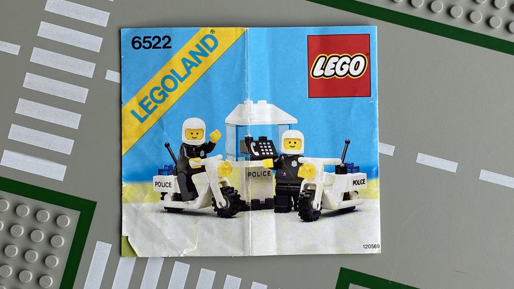 LEGO instruction booklet cover depicting a police telephone booth and two police minifigs each with a police motorcycle