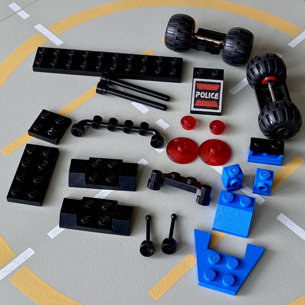 The LEGO pieces for the Message Decoder laid out for building on a classic spaceport baseplate