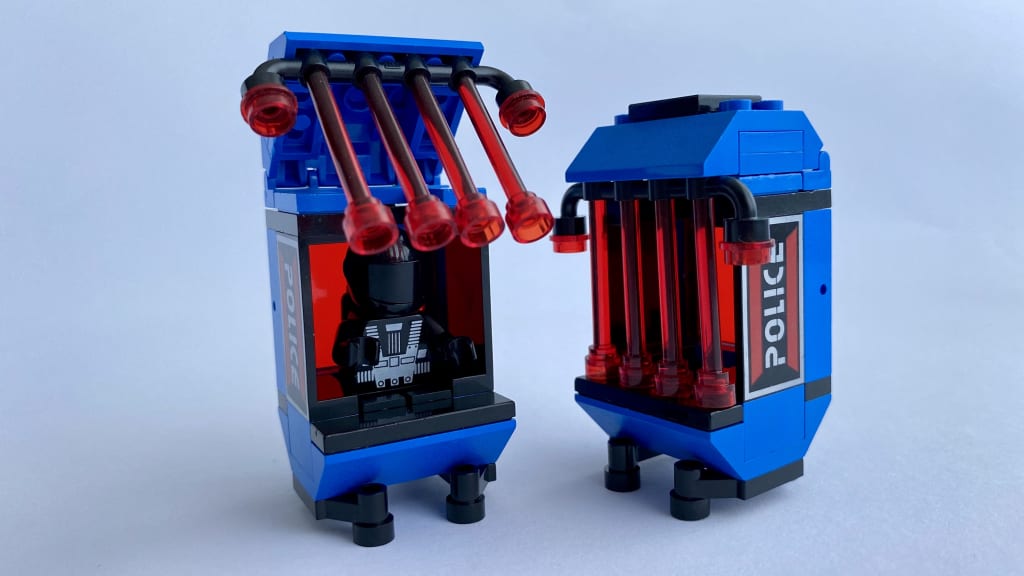 Two detachable prison containers, one of them open with a Blacktron minifigure sitting inside
