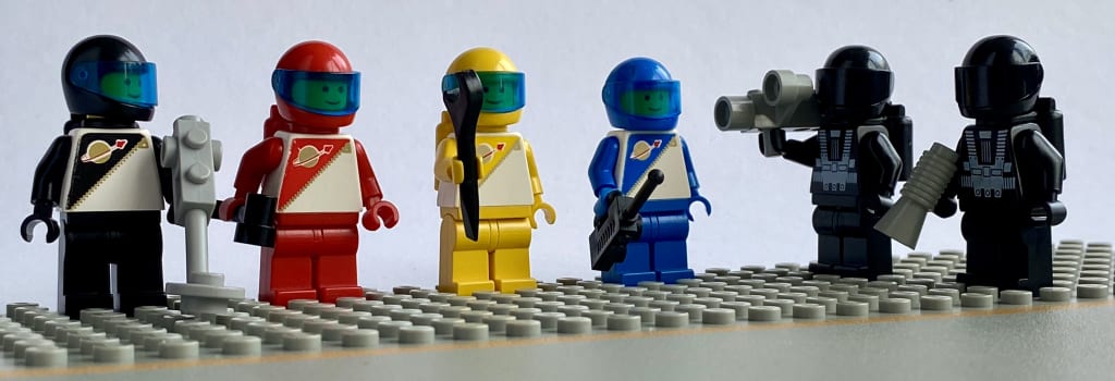 Black, red, yellow and blue Futuron minifigs, and two Blacktron, each holding tool accessories.