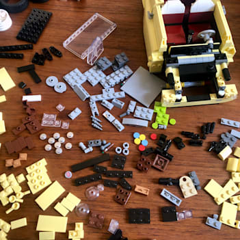 LEGO pieces laid out on a table, with the half built set in the background