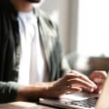 A person enters their information on a laptop to watch an on-demand webinar.