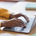 A close-up of hands typing on a laptop