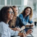 Three coworkers sit in a boardroom and consider content services platforms.