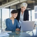 Two women looking at laptop together in office