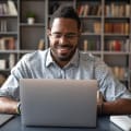 An employee in a home office watches a webinar on a laptop.