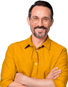 Man in mustard button-down collared shirt smiles at camera.