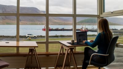 Person works from home overlooking hills and a lake.