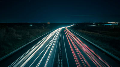 Time-lapse photo of cars on a highway at night.