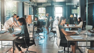 Young professionals work in an open office setting.