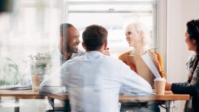 group of 4 people discussing in a meeting