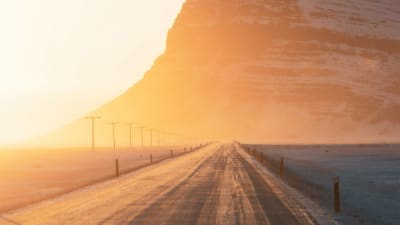 Empty road extends toward mountain.