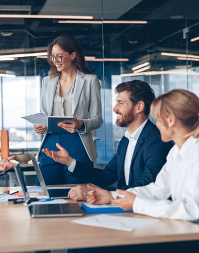 A group of four working professionals are having a work meeting in a modern office setting.