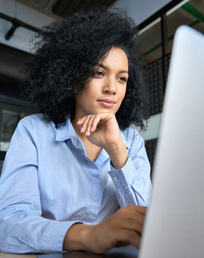 A media professional manages content efficiently on their laptop as they work in an office space.