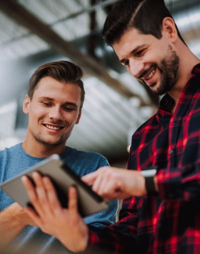 Two co-workers collaborate using a tablet.