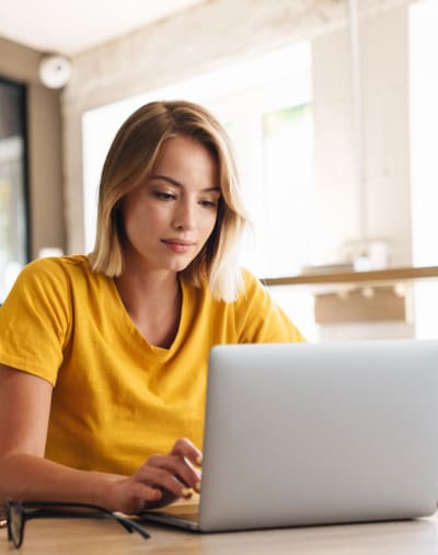 A remote employee works on a laptop from a shared workspace.