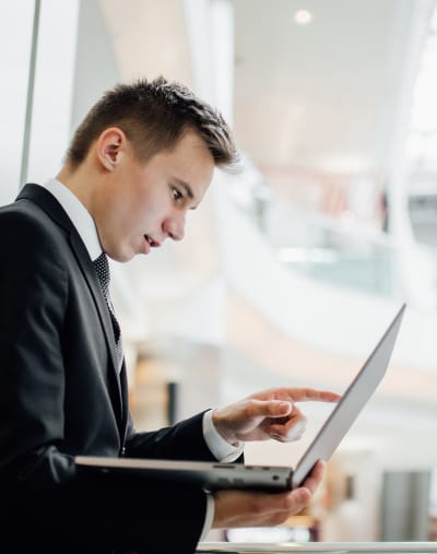 Businessperson points at the screen of a laptop.