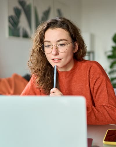 Young person sitting in front of a laptop computer at home.