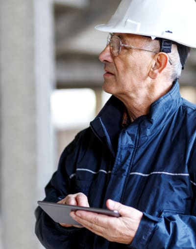 Construction worker wearing a hardhat and holding a tablet.