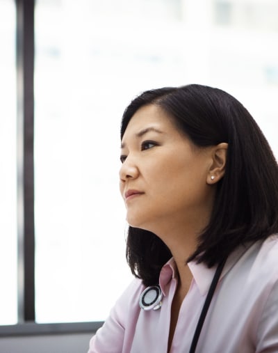 Clinician wearing a stethoscope against a blurred background.