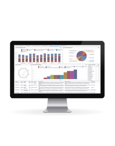 A PC screen shows a reporting dashboard with colorful charts and graphs. 