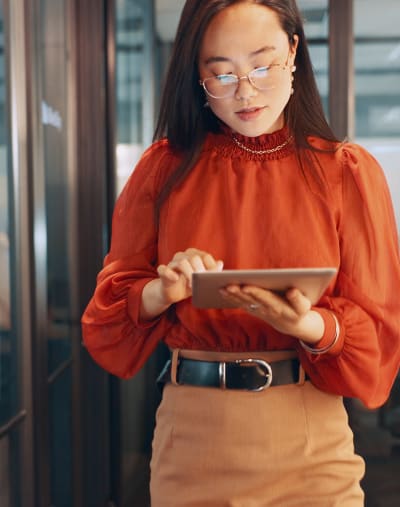 Person in a professional setting looking down at a digital tablet. 