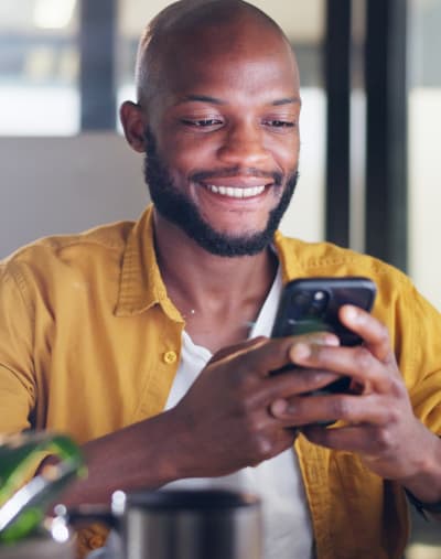 Person smiles and looks at a mobile phone.