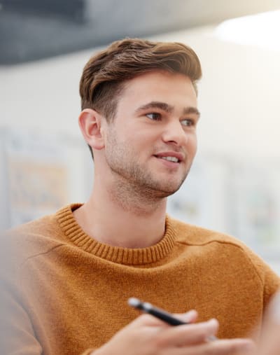 A consultant speaks with a customer, not pictured, while holding a writing instrument.