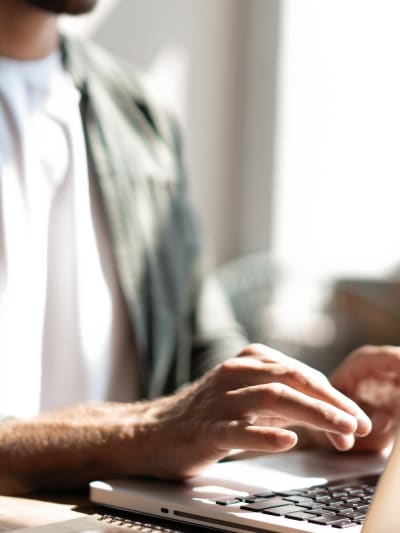 A person enters their information on a laptop to watch an on-demand webinar.